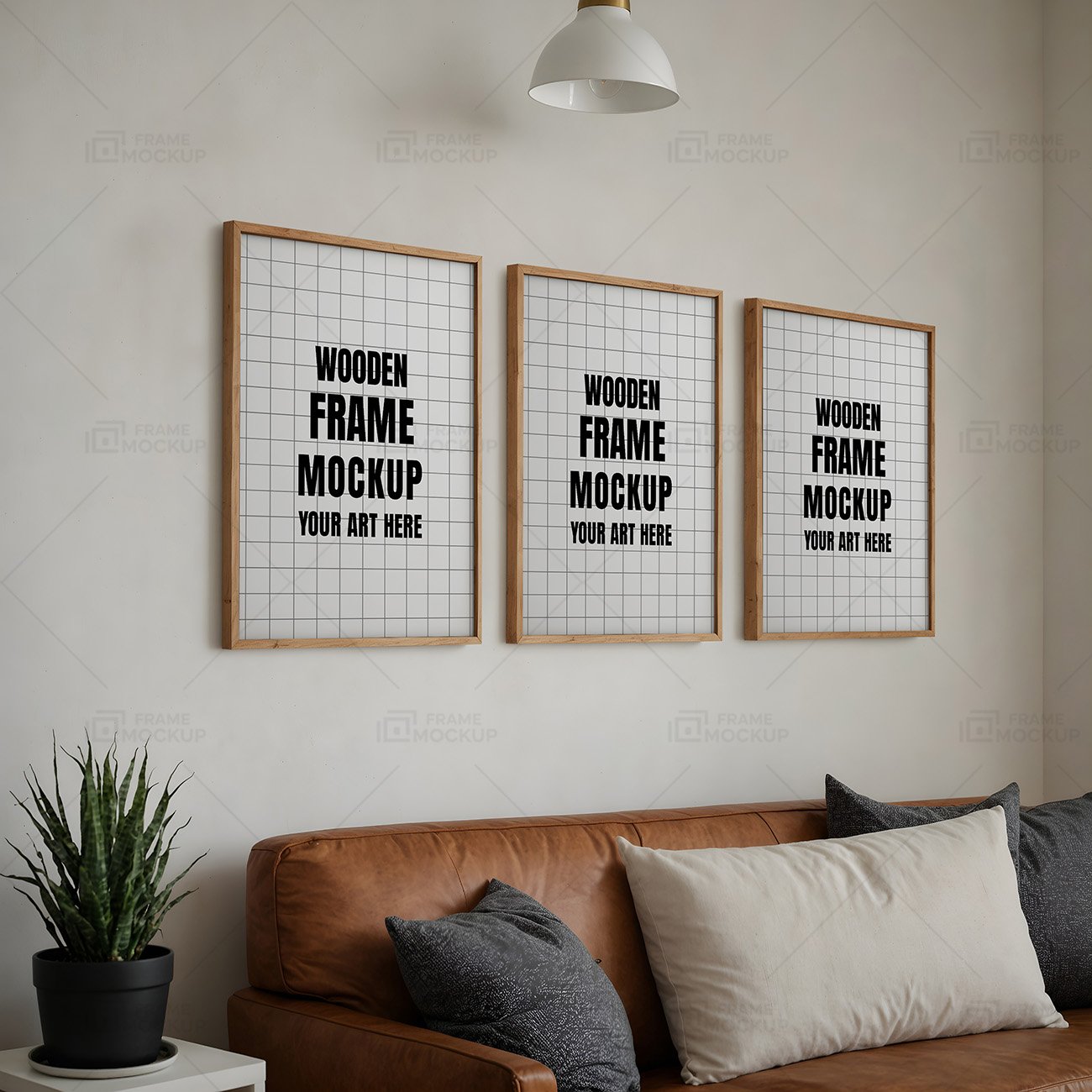 Three wooden frame mockups with blank interiors displayed on a wall above a brown leather sofa, accompanied by decorative pillows and a potted plant.