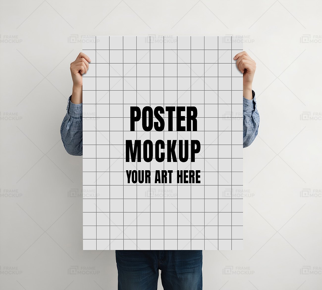 A person in a blue shirt holding a blank white poster board in front of a light gray background.